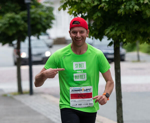 Bilde av Victor Supersaxo som løper med grønn t-skjorte med skriften si det for å bli det. 