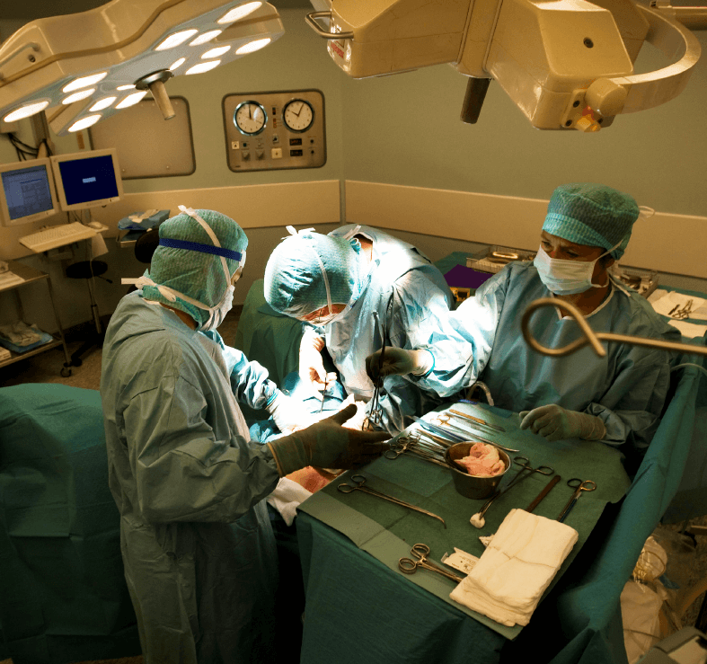 Foto fra operasjonssal hvor tre kirurger står ved operasjonsbordet